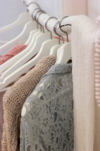 Soft colored sweaters hanging 