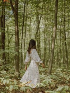  A woman wearing a white maxi dress in the woods